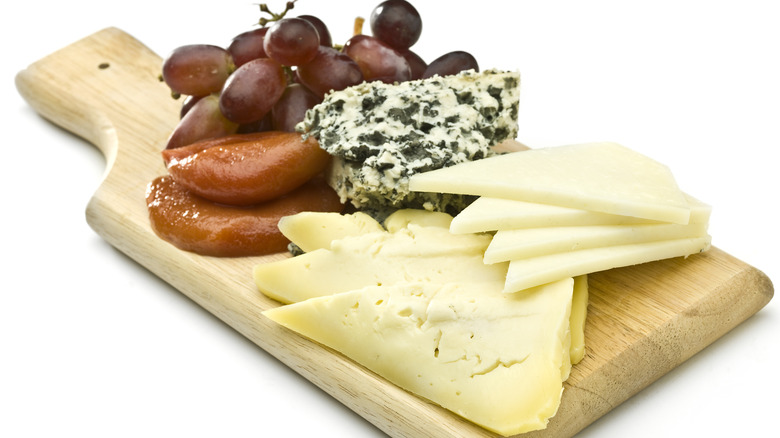 Manchego with fruits on a cutting board