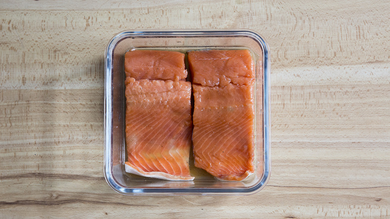 salmon marinating in clear container