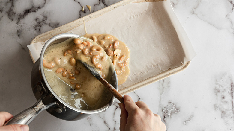 Pouring cashew brittle mix into pan