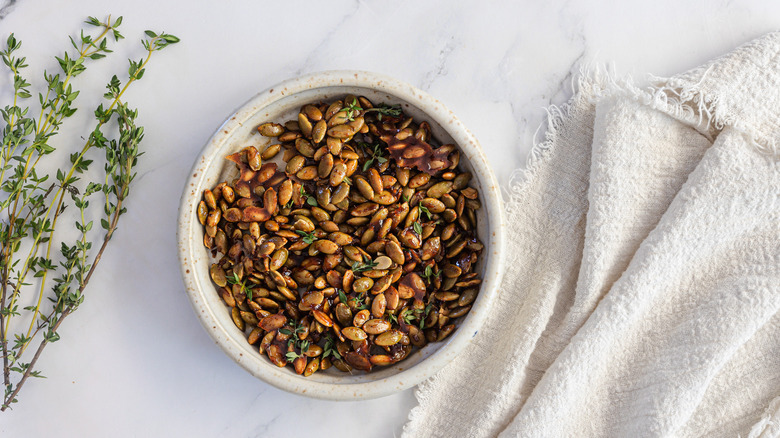 Maple seeds in white bowl with napkin and thyme