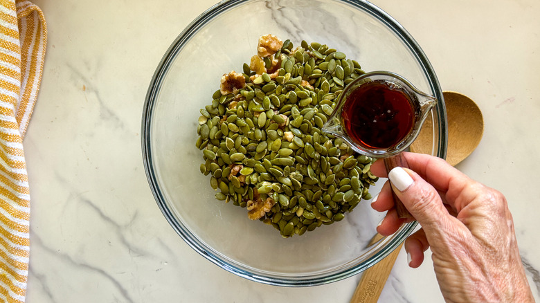 hand adding syrup to bowl