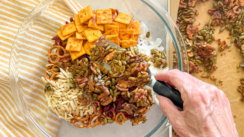 hand adding nuts to bowl