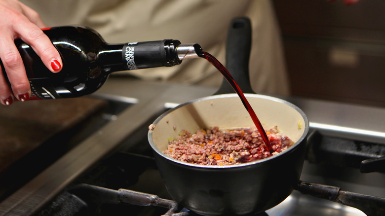 Adding red wine to meat mix