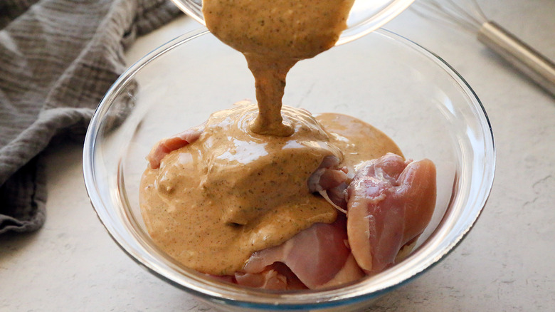Pouring tahini over chicken