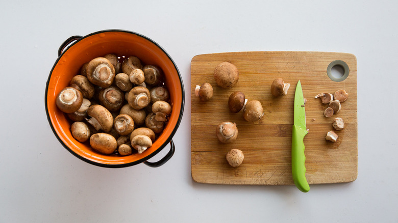 cutting mushroom stems on board