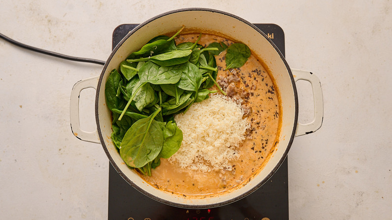 Spinach and Parmesan sitting on top of a pot of soup