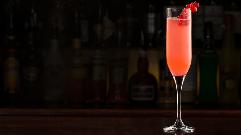 Redcurrant champagne cocktail with fresh redcurrants in glass