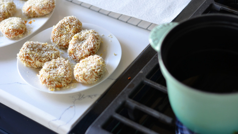 pot of oil next to coated croquettes