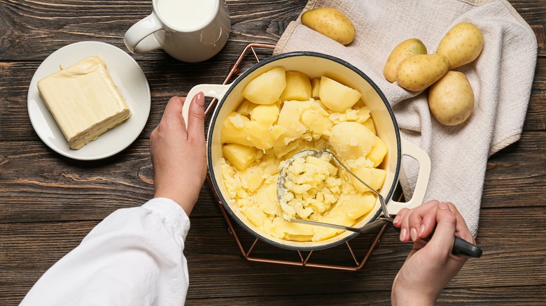 Person mashing potatoes