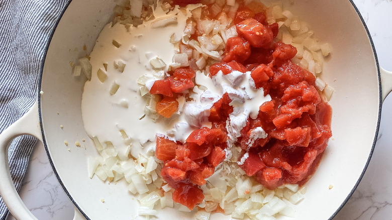 onions, cream, tomatoes in pan