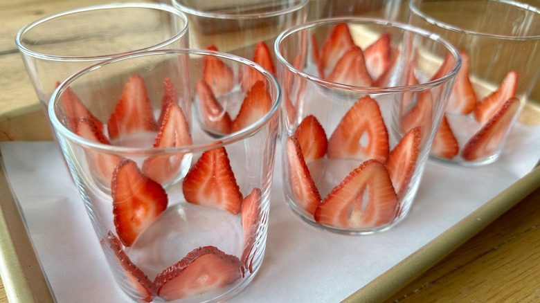 Sliced strawberries lining glasses