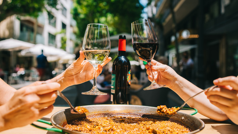 People toasting with wine glasses outside at restaurant