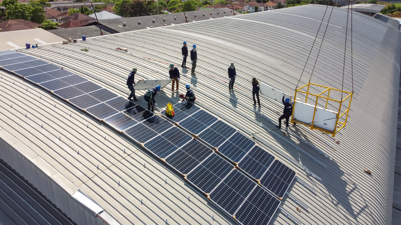 People installing solar panels on a roof