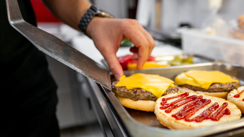 Chef preparing fast food cheeseburgers