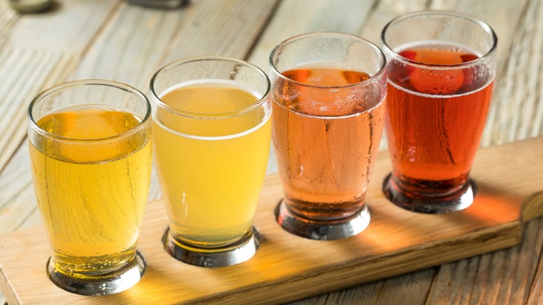 A flight of cider on a wooden board