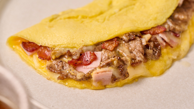 close up of meat in omelette