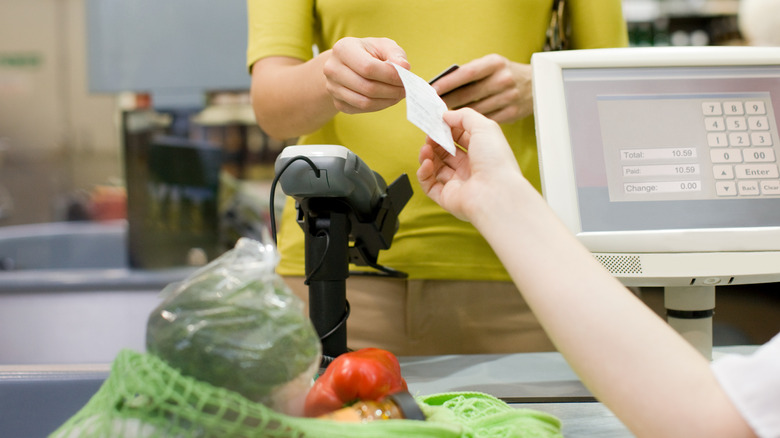 woman paying at grocery store