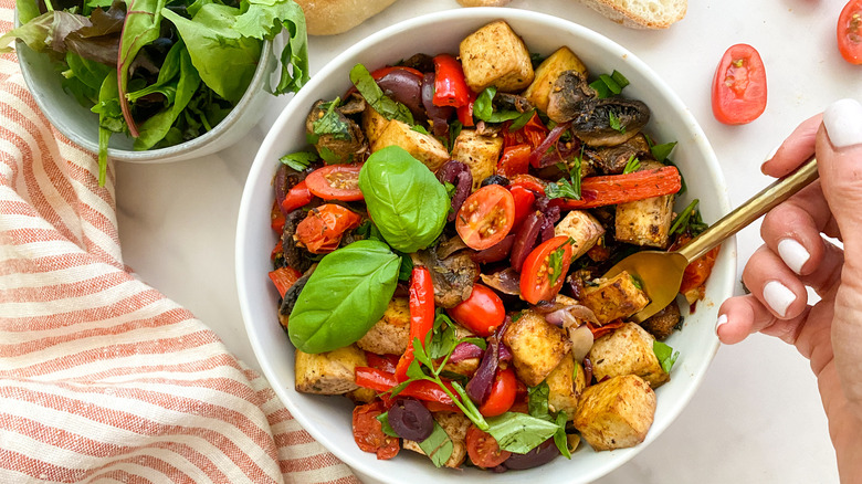 Hand forking tofu in bowl