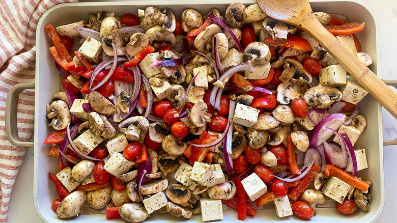 Baking sheet with Mediterranean sheet pan tofu ingredients.