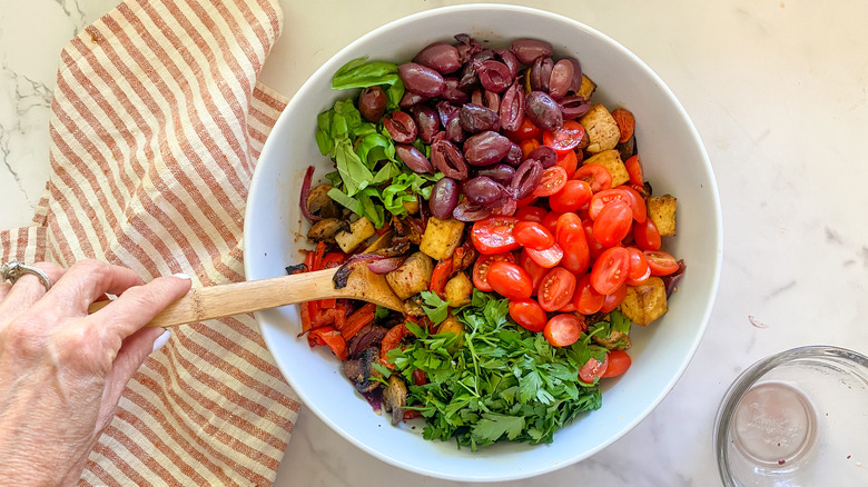 Hand stirring ingredients in white bowl.