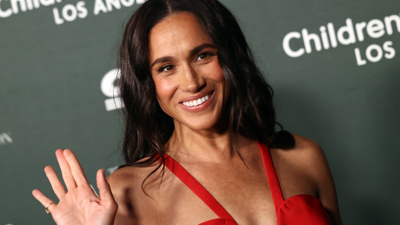 Meghan Markle smiling in red dress