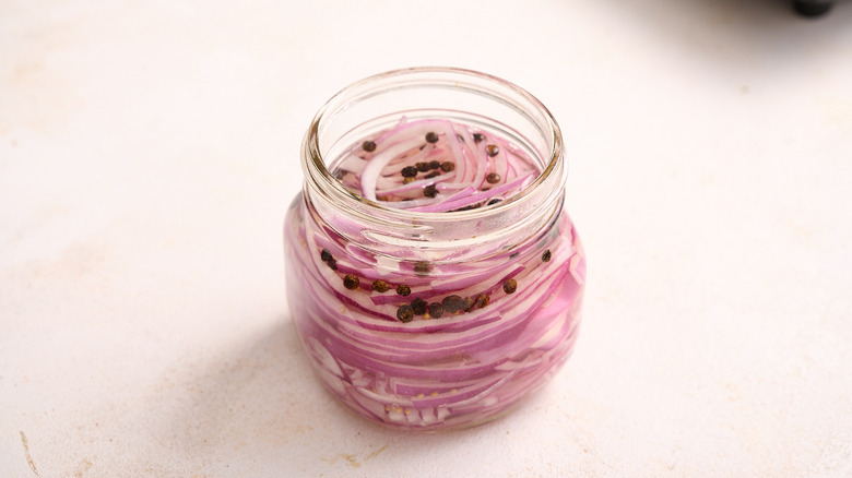Onions submerged in vinegar in glass jar