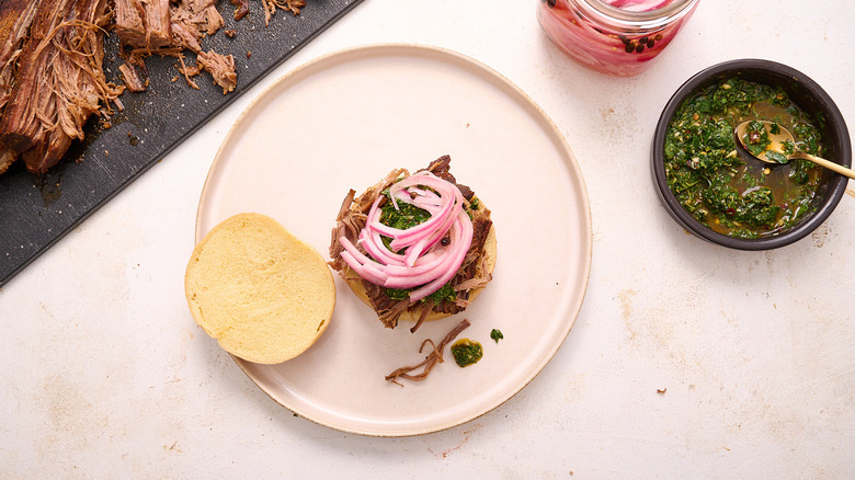 Brisket piled onto brioche bun with pickled onions