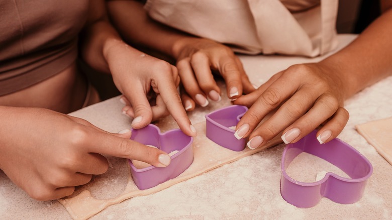 A mother and daughter using cookie cutters