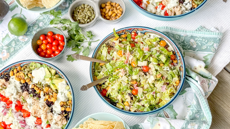 Mexican-inspired tuna salad in serving dishes on table with garnishes