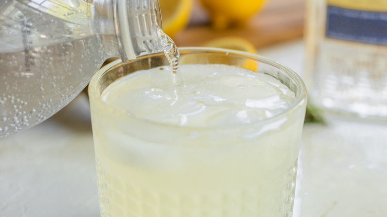 pouring club soda into cocktail