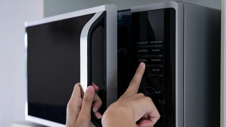  hands closing microwave oven door
