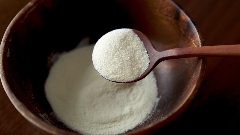 milk powder in wooden bowl with wooden spoon