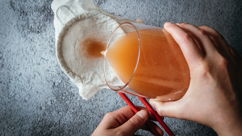 Pouring orange liquid through strainer