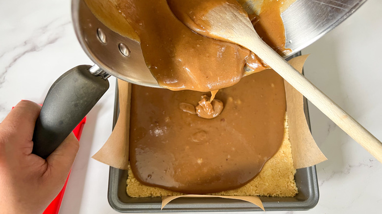 pouring caramel over shortbread base