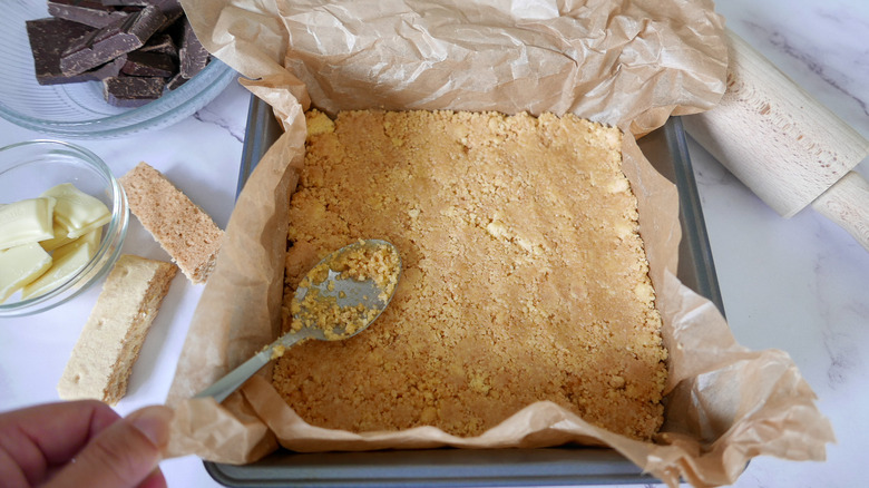 pressing shortbread base into pan