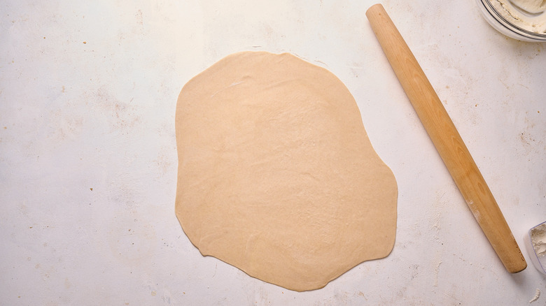 rolling dough out on table