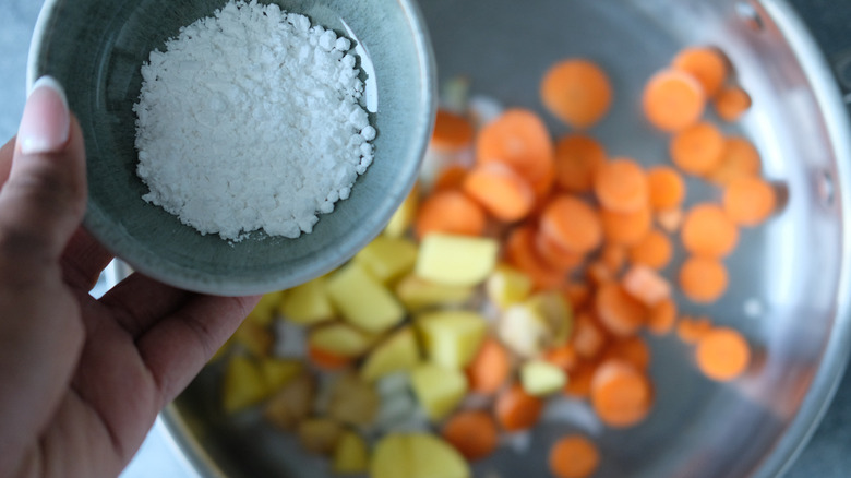 adding flour to sauteed vegetables