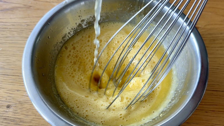 Pouring hot liquid into egg yolks