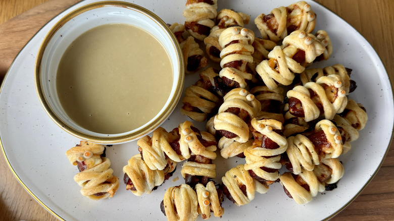 Serving mini sausage mummies with honey mustard sauce