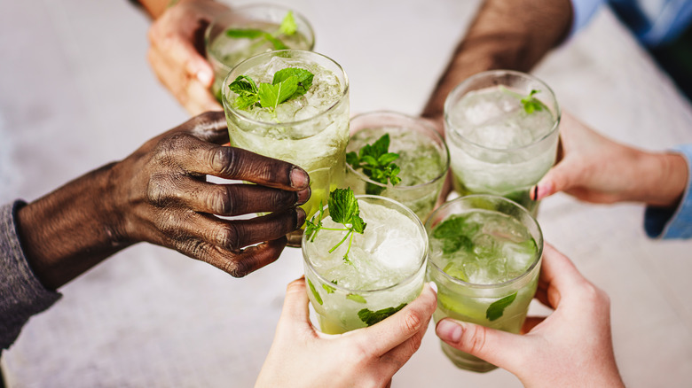 Group of people toasting with mojito cocktails