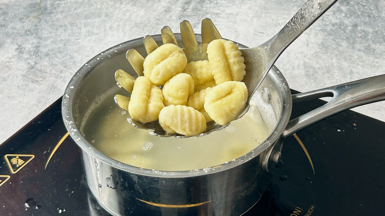 straining cooked gnocchi from water