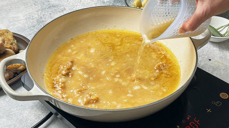 pouring broth into skillet