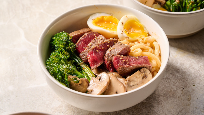 sesame beef noodle bowl on table