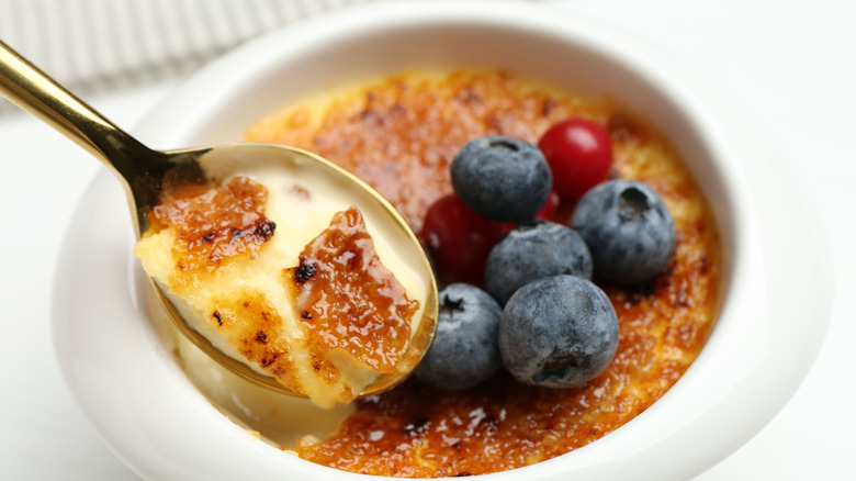 spoon with creme brulee and fresh berries