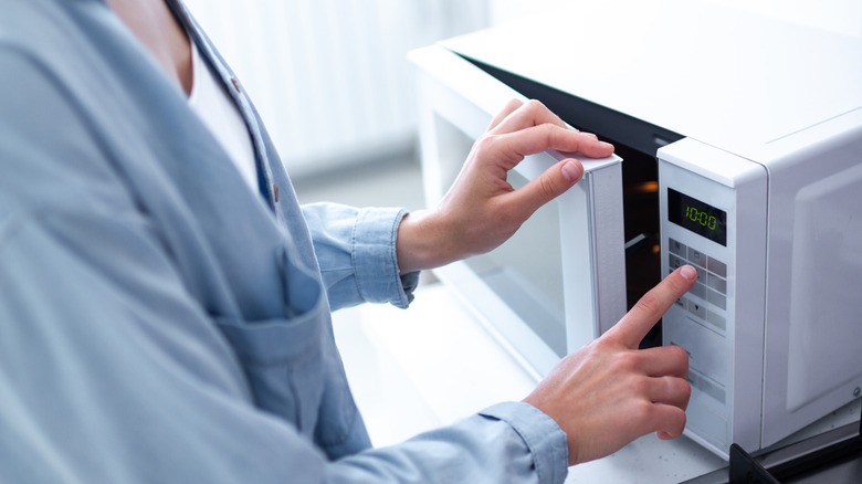 Person using microwave to heat food