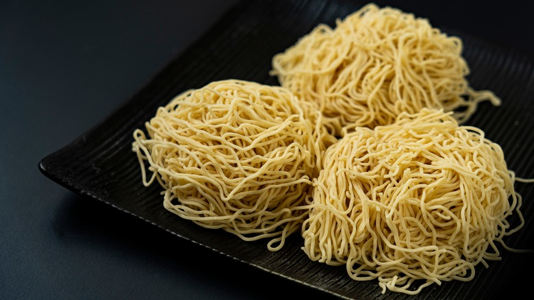 three balls of raw ramen noodles