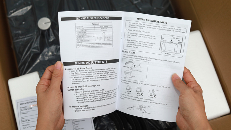 person flipping through a printed stove manual