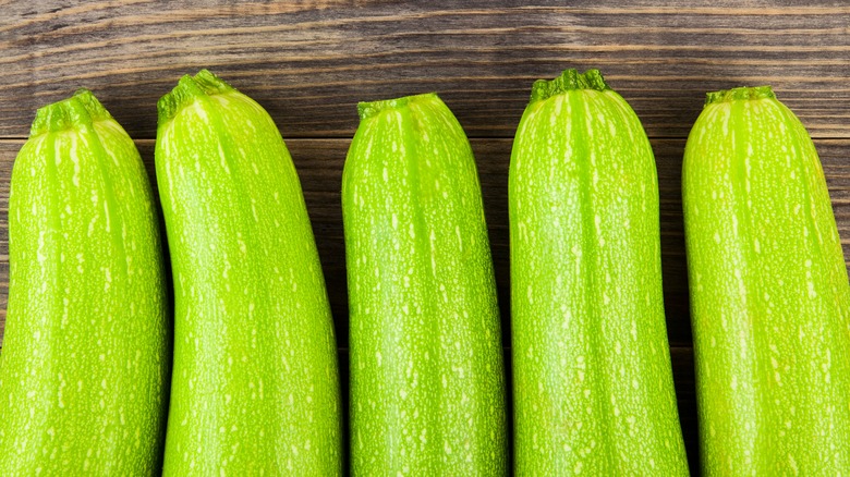 fresh whole zucchini wood background