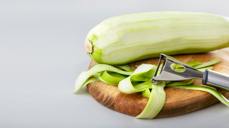 whole and peeled zucchini with vegetable peeler