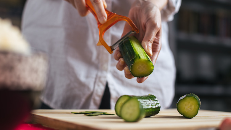 Chef peeling cucumber